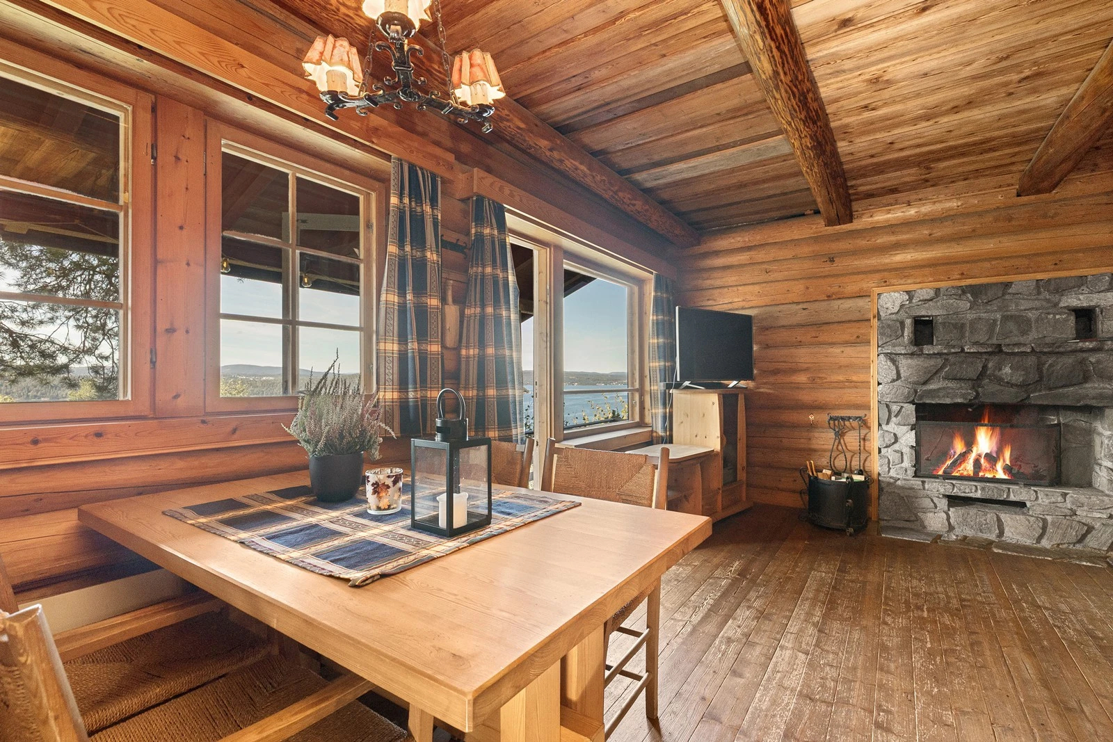 Stue og spisestue med peisovn og gode vindusflater mot fjorden Galleribilde