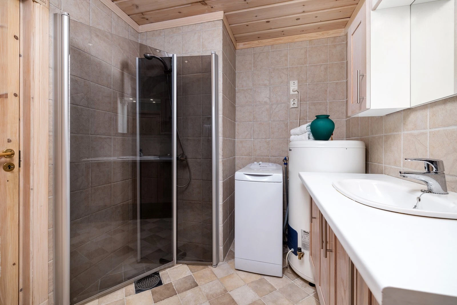 Rommet er innredet med tidløse farger og materialer, med fliser på gulv og vegger. Galleribilde