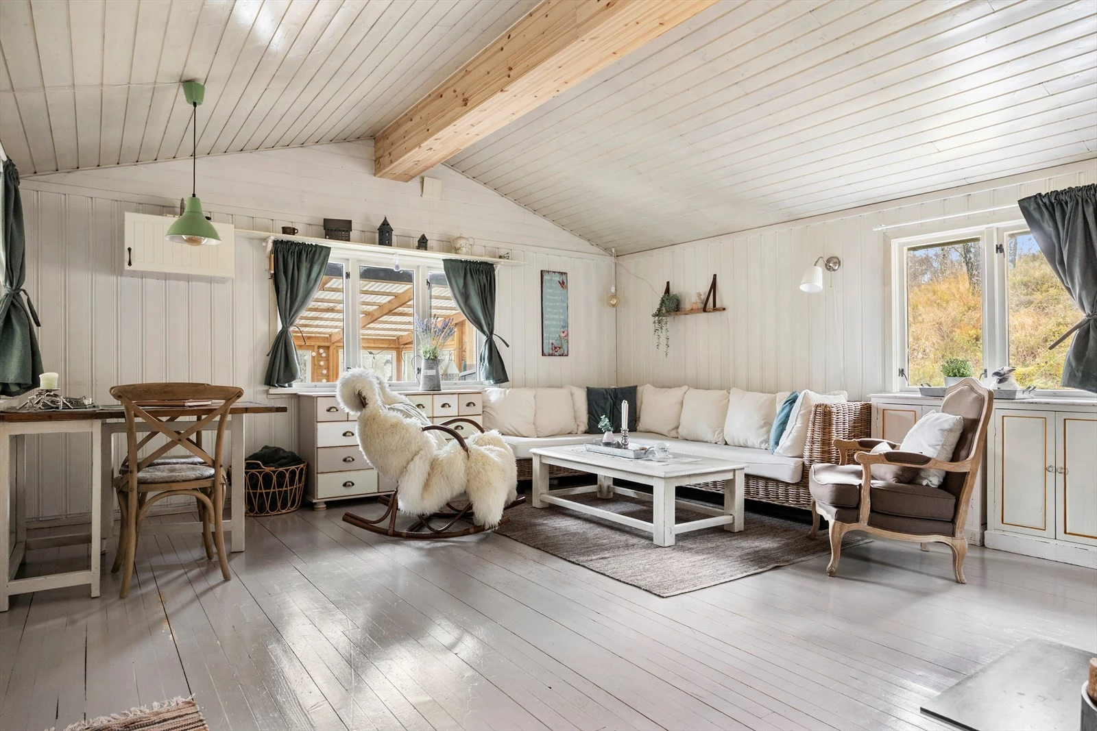 Den lyse og romslige stuen har plass til både sittegruppe og spisebord. Ekstra takhøyde gir en god romfølelse og store vinduer slipper inn rikelig med naturlig lys. Den nye peisovnen fra 2015 gir både varme og en hyggelig atmosfære på kalde dager. Galleribilde