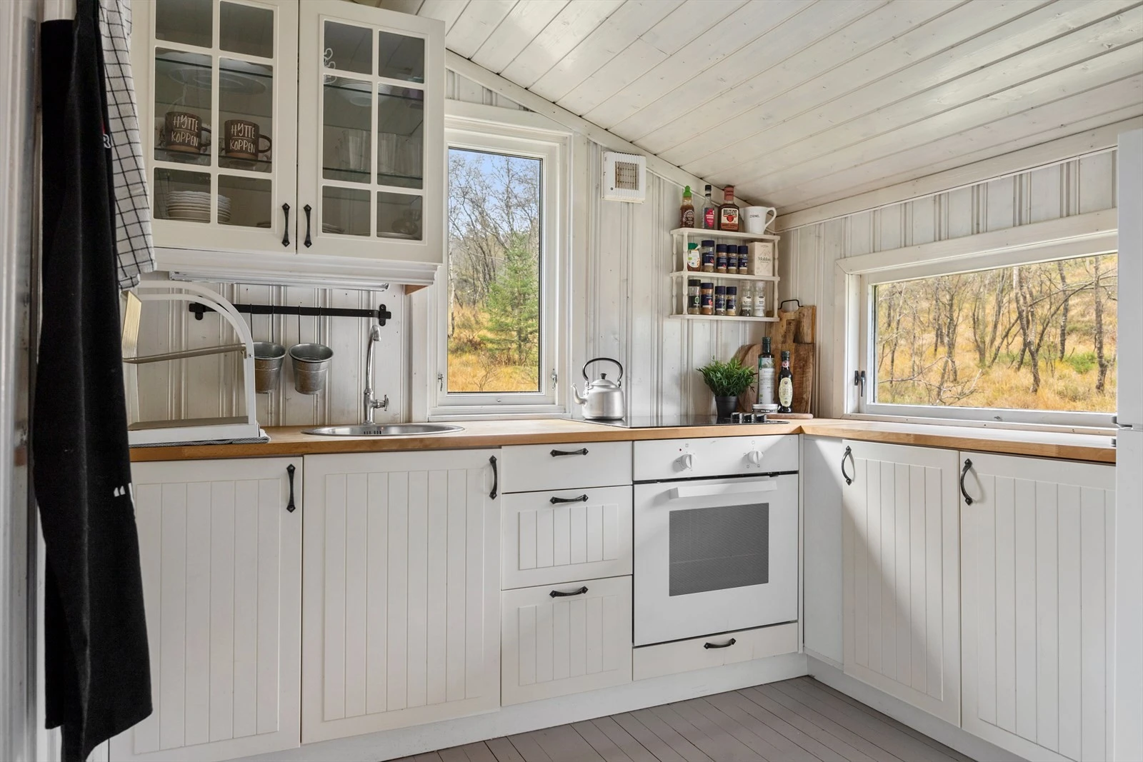 Kjøkkenet har profilerte fronter og en benkeplate av bøk med nedfelt vask. Kjøkkenet er utstyrt med integrert koketopp og ovn, noe som gjør matlagingen både enkel og effektiv. Galleribilde