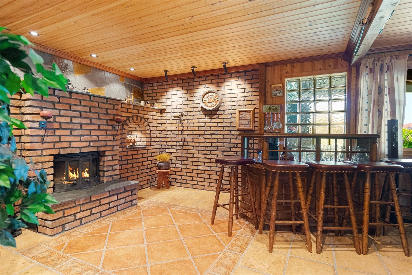 Koselig kjellerstue som er fliselagt og utstyrt med vedfyring Galleribilde