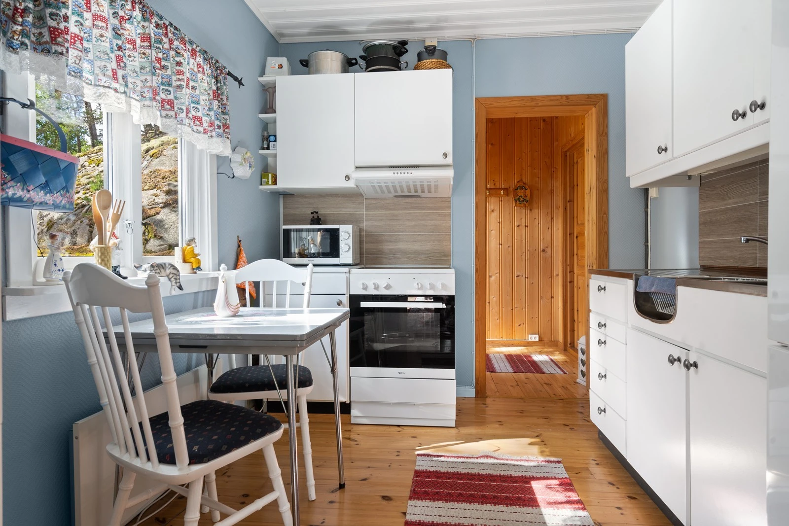 Separat kjøkken mellom gang og stue, med malt fiskebeinsstrie på veggene og tregulv, malt trepanel i taket. På kjøkkenet er det en innredning med malte fronter. Det er avsatt plass til frittstående komfyr med ventilator over, samt kjøl-/fryseskap Galleribilde