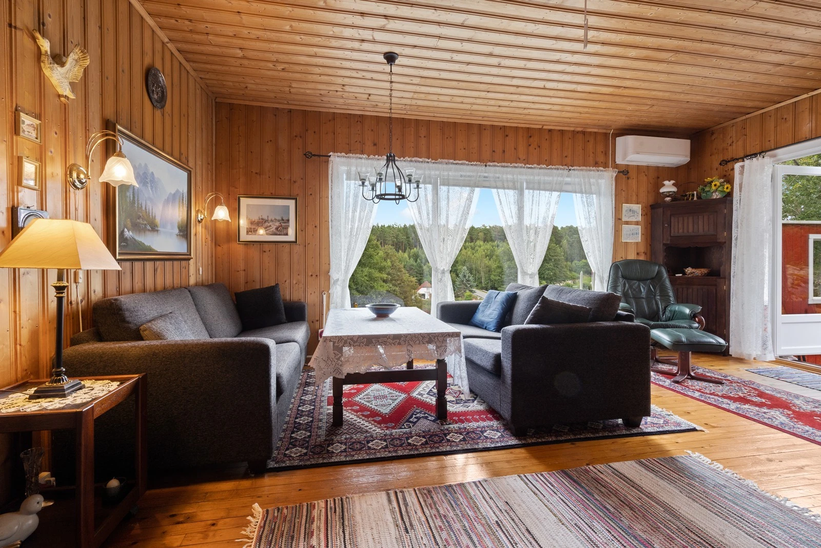 Romslig stue, med plass til blant annet salong med tilhørende bord og småmøbler. Store stuevinduer slipper inn rikelig med dagslys - i tillegg er det utgang til den fine, hellelagte uteplassen i fra stua Galleribilde