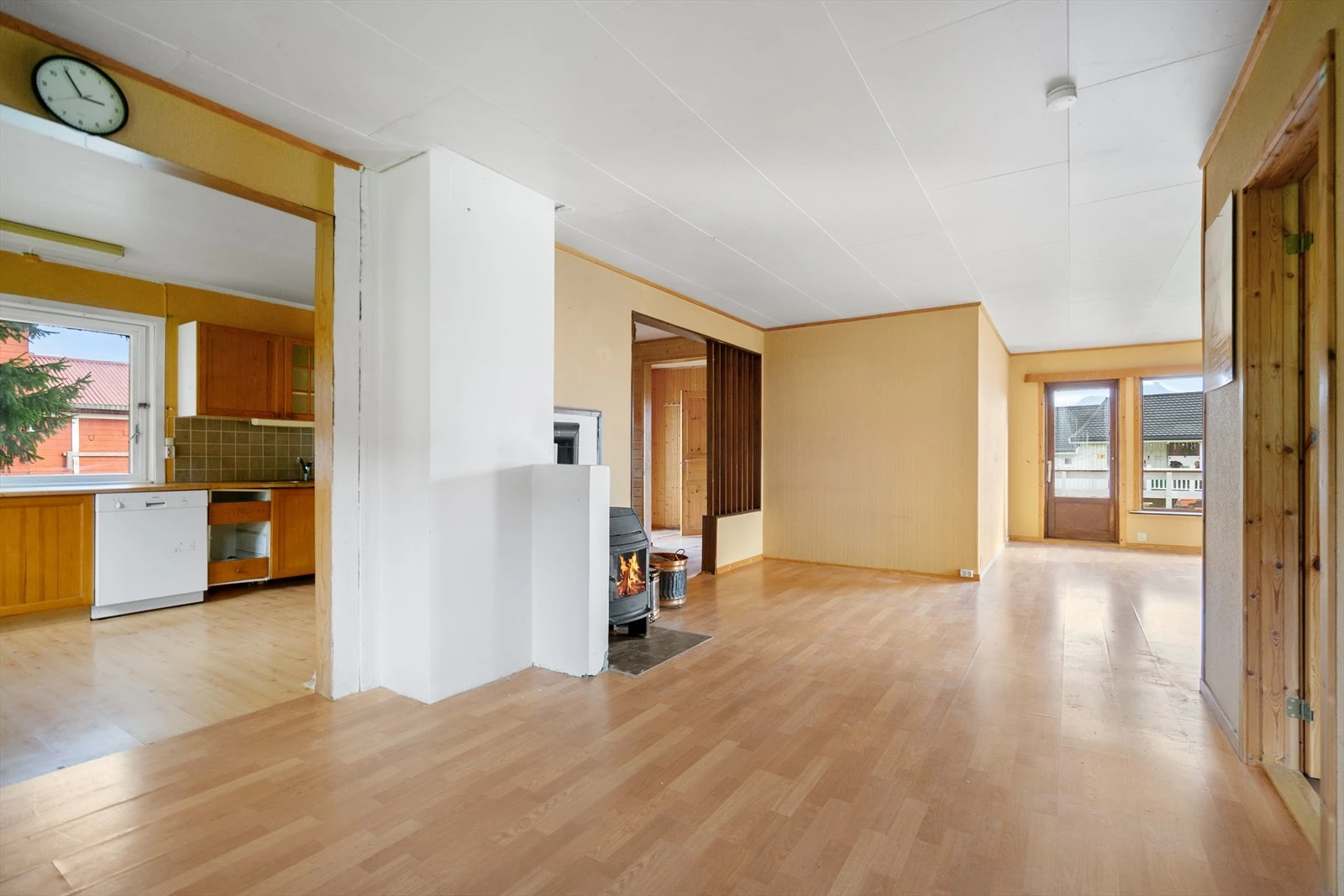 Lys og luftig stue med store vinduer og vedovn som gir en koselig atmosfære Galleribilde