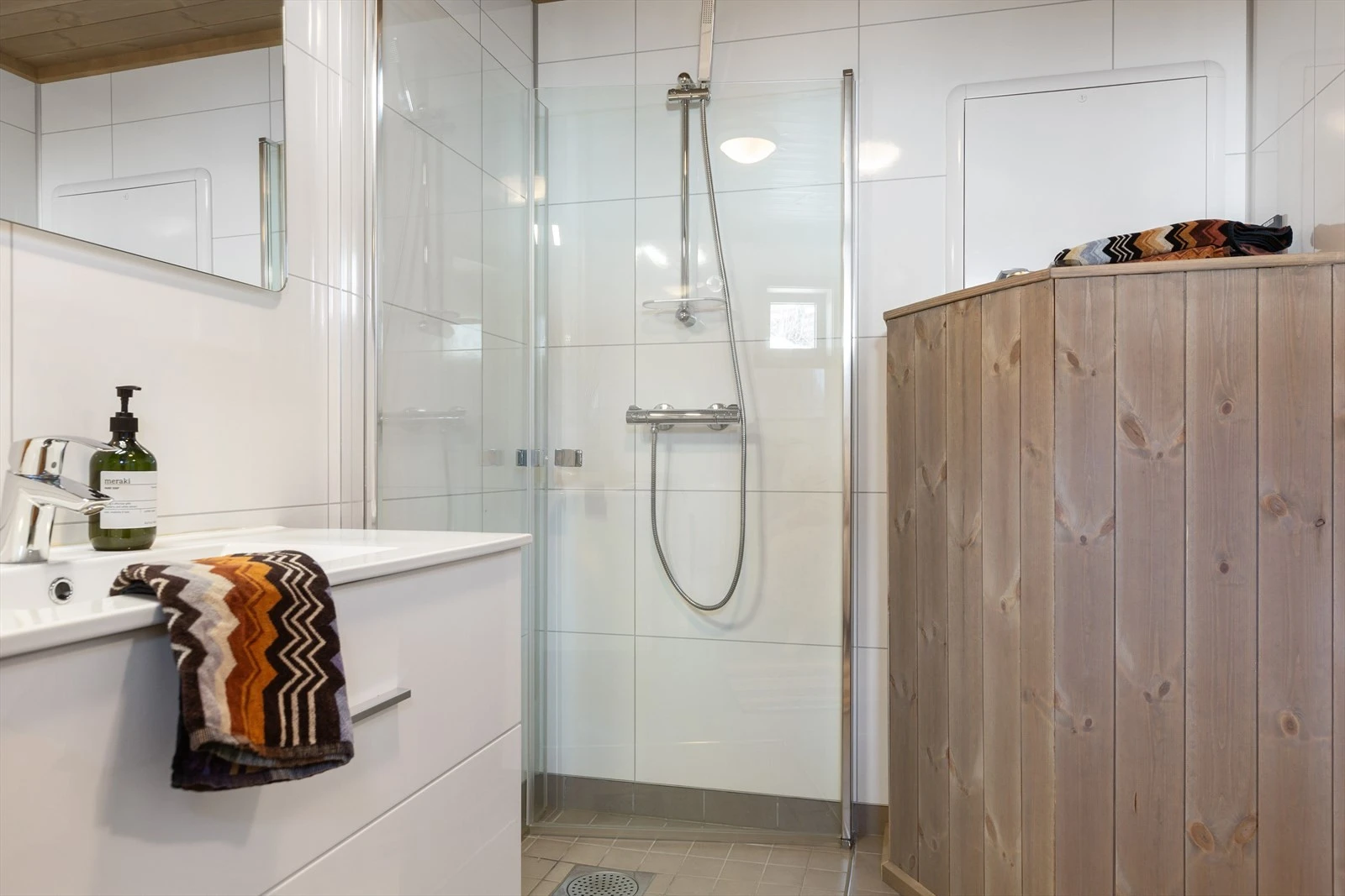 Skapinnredning med servant, dusjvegger i glass, og vegghengt toalett. Galleribilde