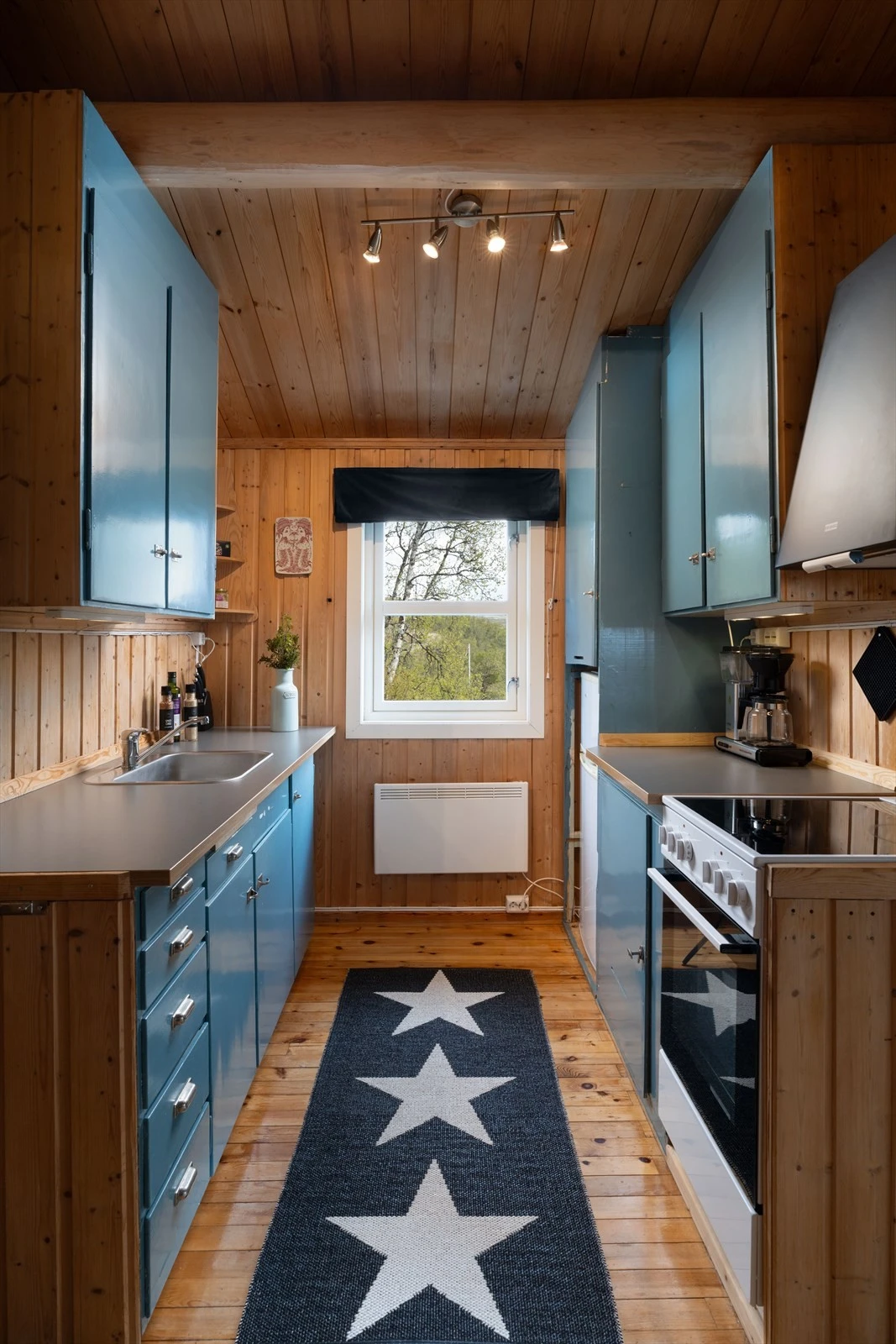 Kjøkkeninnredning med over- og underskap med slette fronter og laminert benkeplate med nedfelt oppvaskbeslag Galleribilde