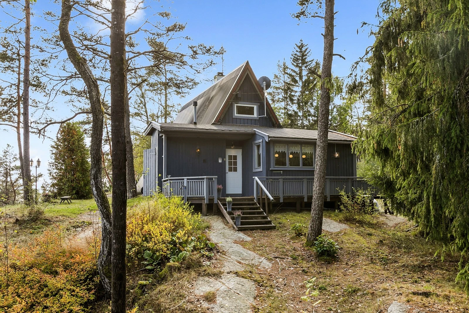 Fra parkering leder en kort sti og noen trappetrinn opp til en koselig velkomstterrasse på 17 kvm, med plass til et hyggelig cafésett eller en sittegruppe. Galleribilde