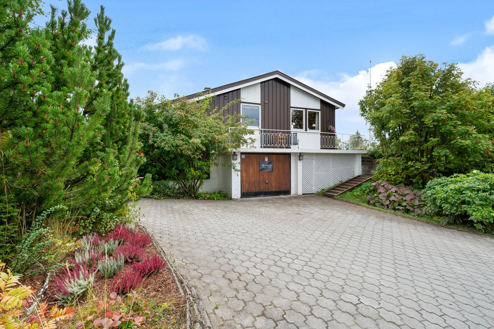 Stor gårdsplass med belegningsstein og garasje gir parkering for flere biler Galleribilde