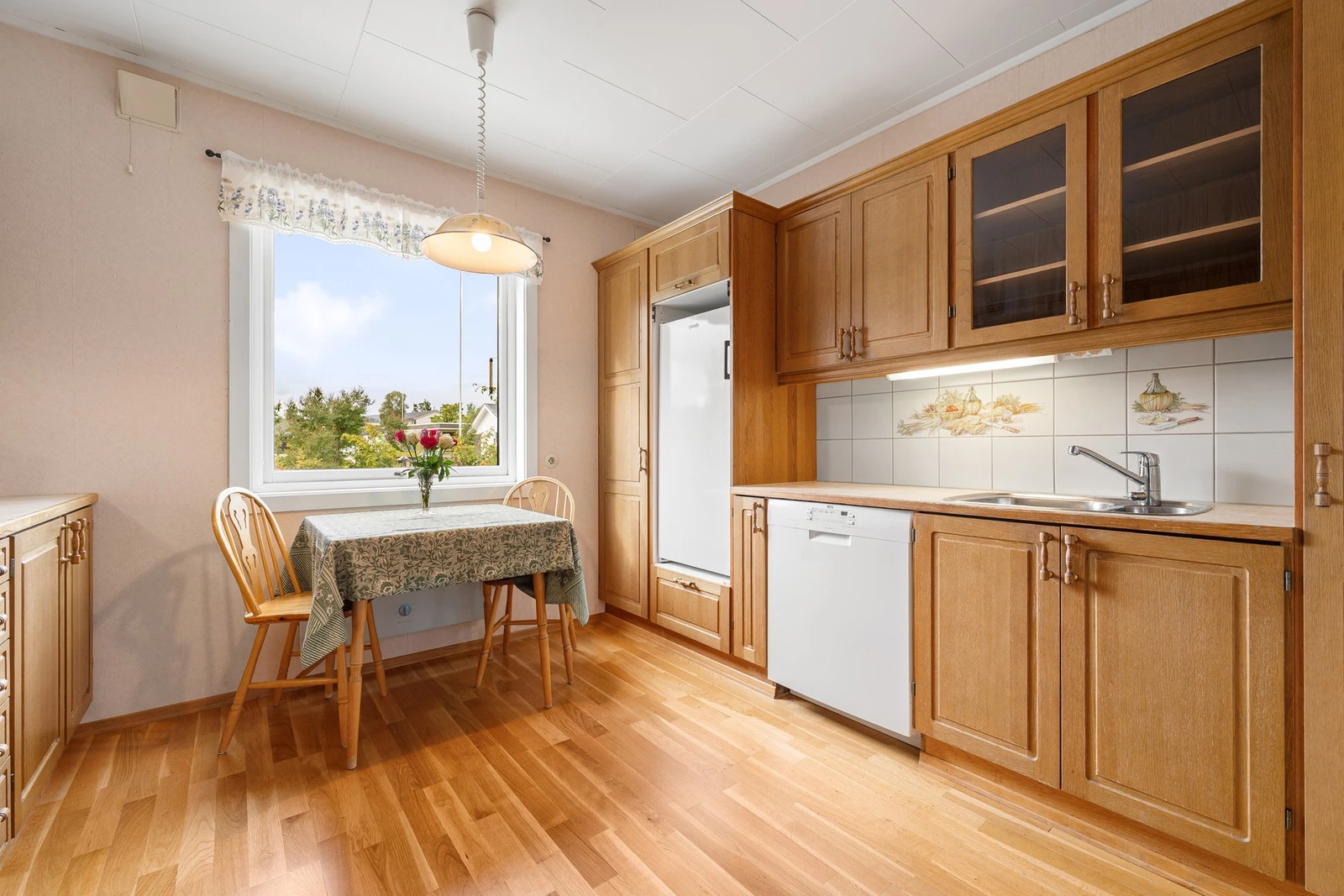 Innredning med profilerte fronter i tre, enkelte glassdører, og laminat benkeplate Galleribilde