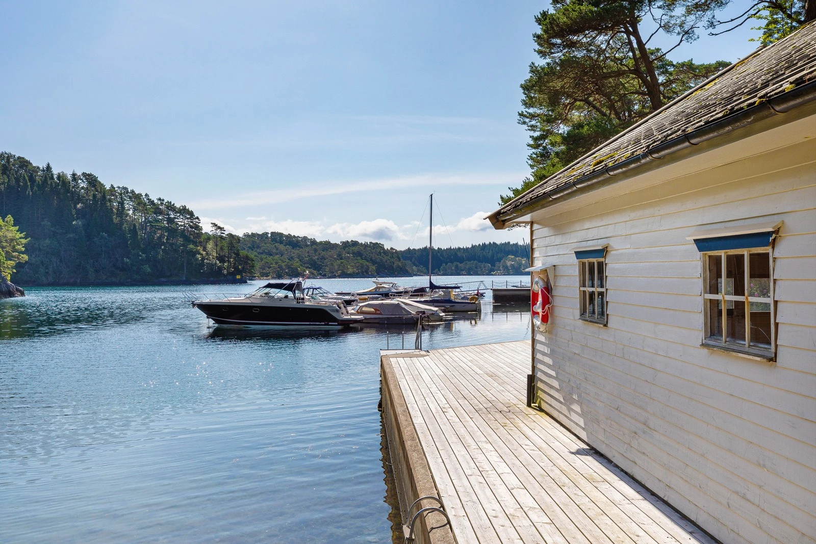 Dette båthuset ligger like innenfor flytebryggen . Galleribilde