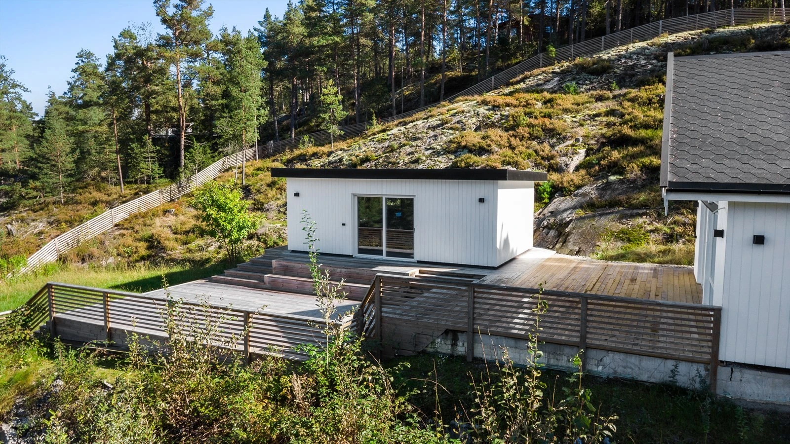 Nordvendt terrasse på 92 m² binder sammen hovedhytta og annekset. Galleribilde