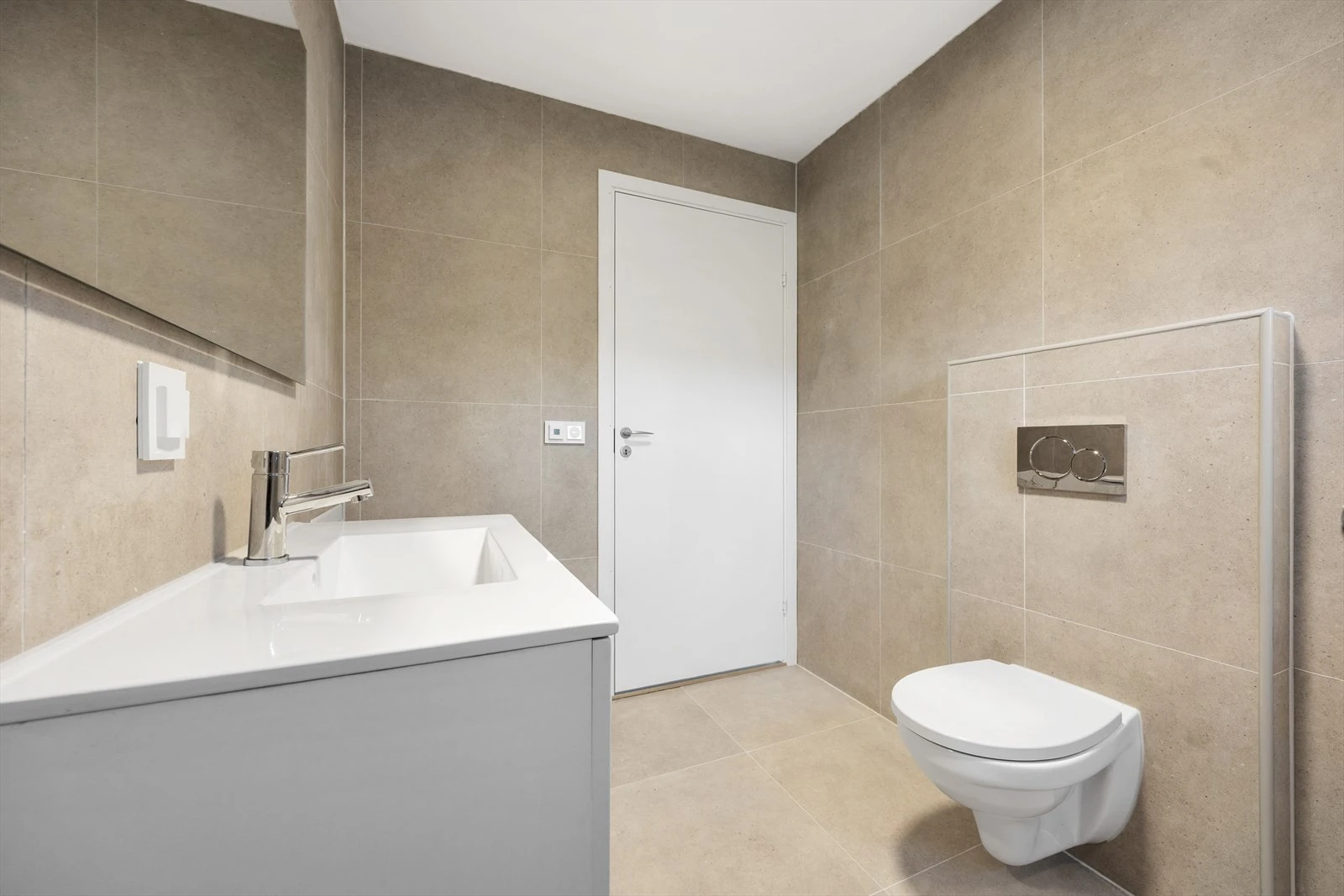 Elektriske varmekabler i gulvet, vegghengt toalett og en moderne servantseksjon. Galleribilde