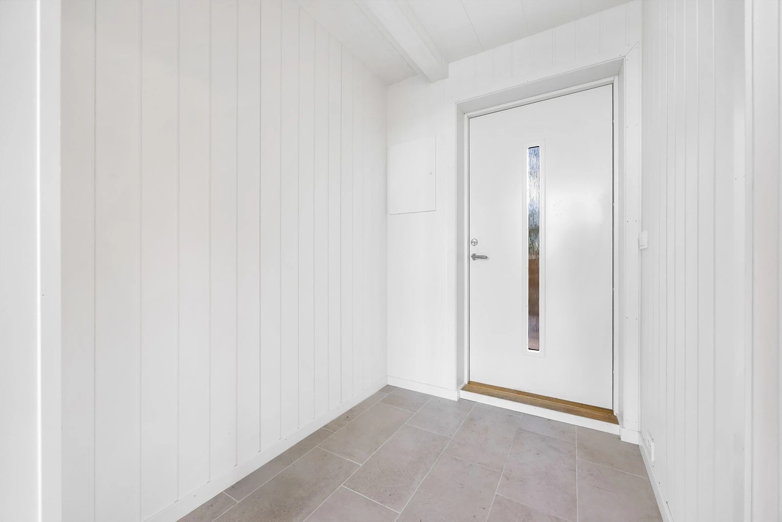 Lys entré med flislagt gulv og vannbåren varme. Galleribilde