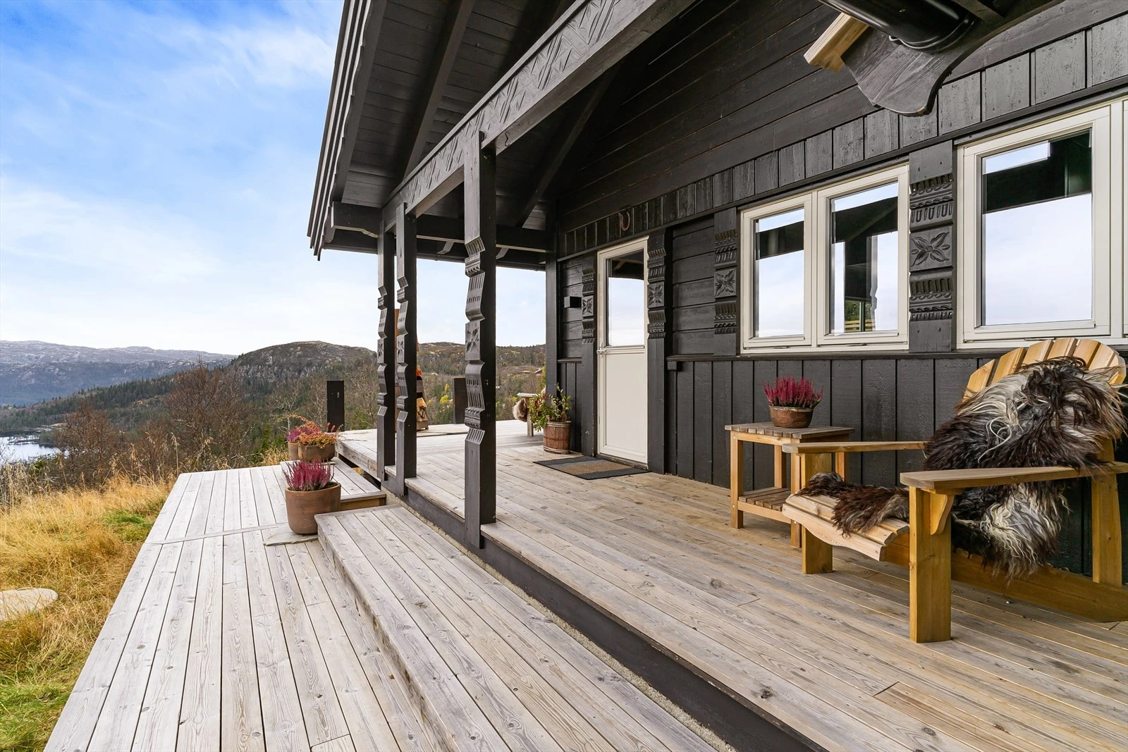 Terrasseplattingene strekker seg rundt på hyttas syd og vestvegg - og med sportsboden i ryggen og takoverbygg fra hytta, får man en lun og skjermet krok utendørs. Galleribilde