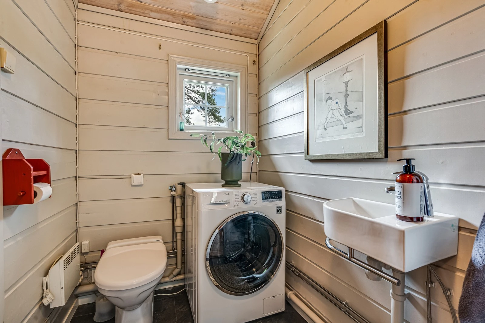 Toalettrom med vask, toalett og vaskemaskin. Galleribilde