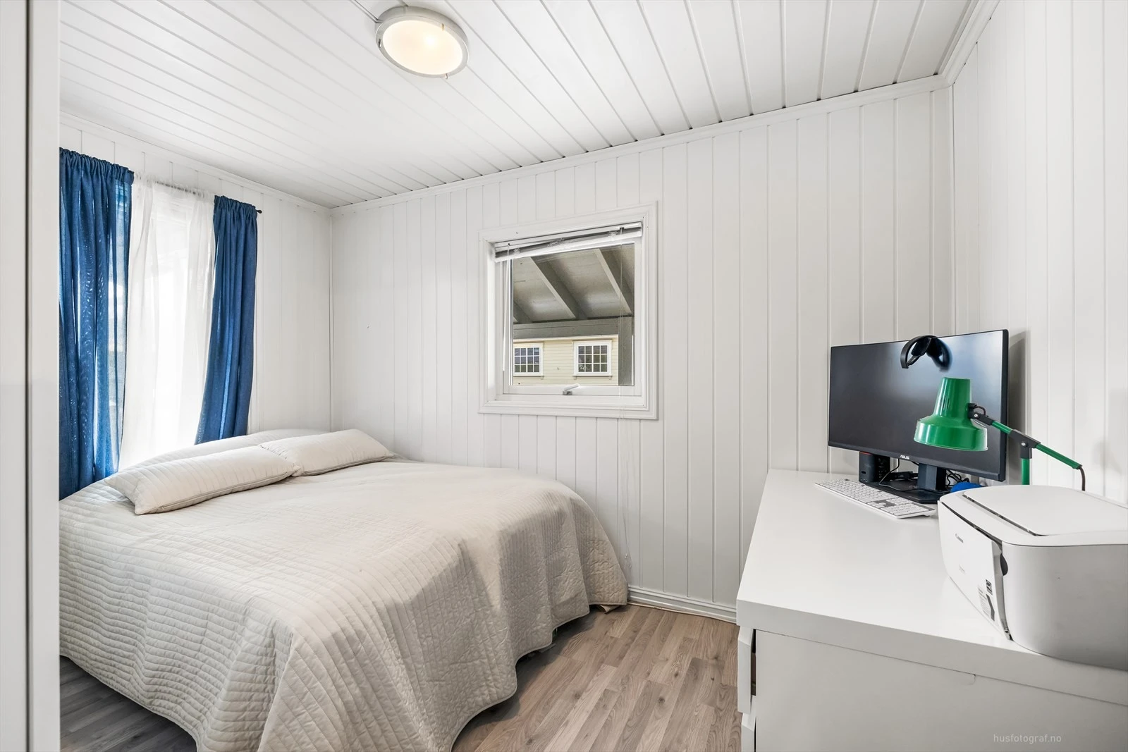 Lys og velholdt soverom med plass til dobbeltseng og arbeidsområde.