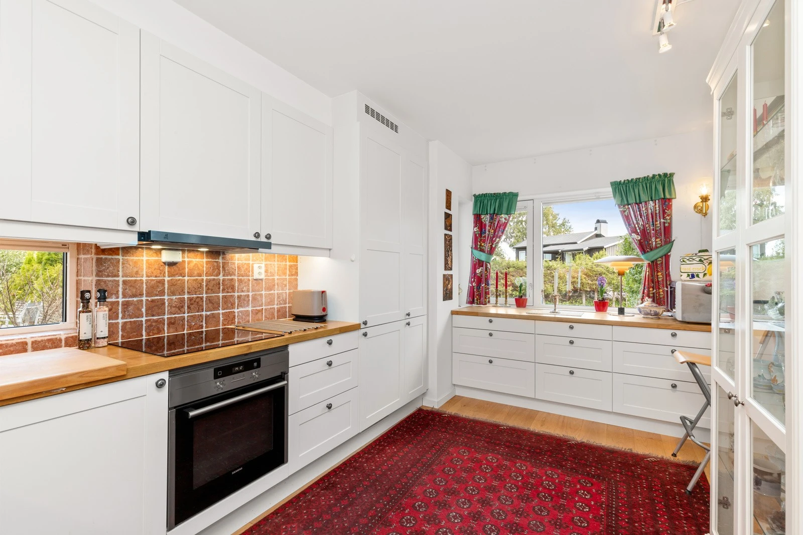 Kjøkkenet har nedsenket oppvaskkum, stekeovn, oppvaskmaskin, kjøleskap med fryser, induksjonstopp og ventilator med belysning. Galleribilde