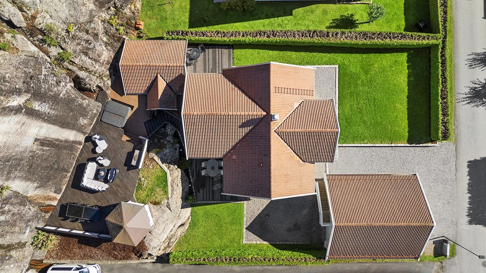 Tomten er pent opparbeidet med hyggelig hageområde samt solrike terrasser og uteområder Galleribilde