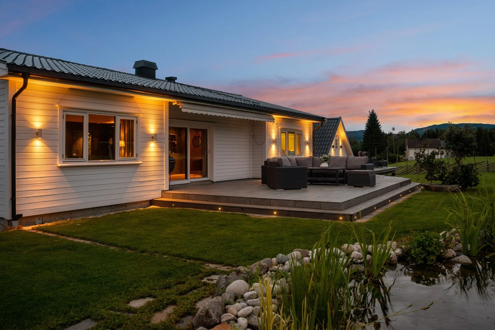 Gjennomført utebelysning som fremhever boligen og uteplassen. Galleribilde