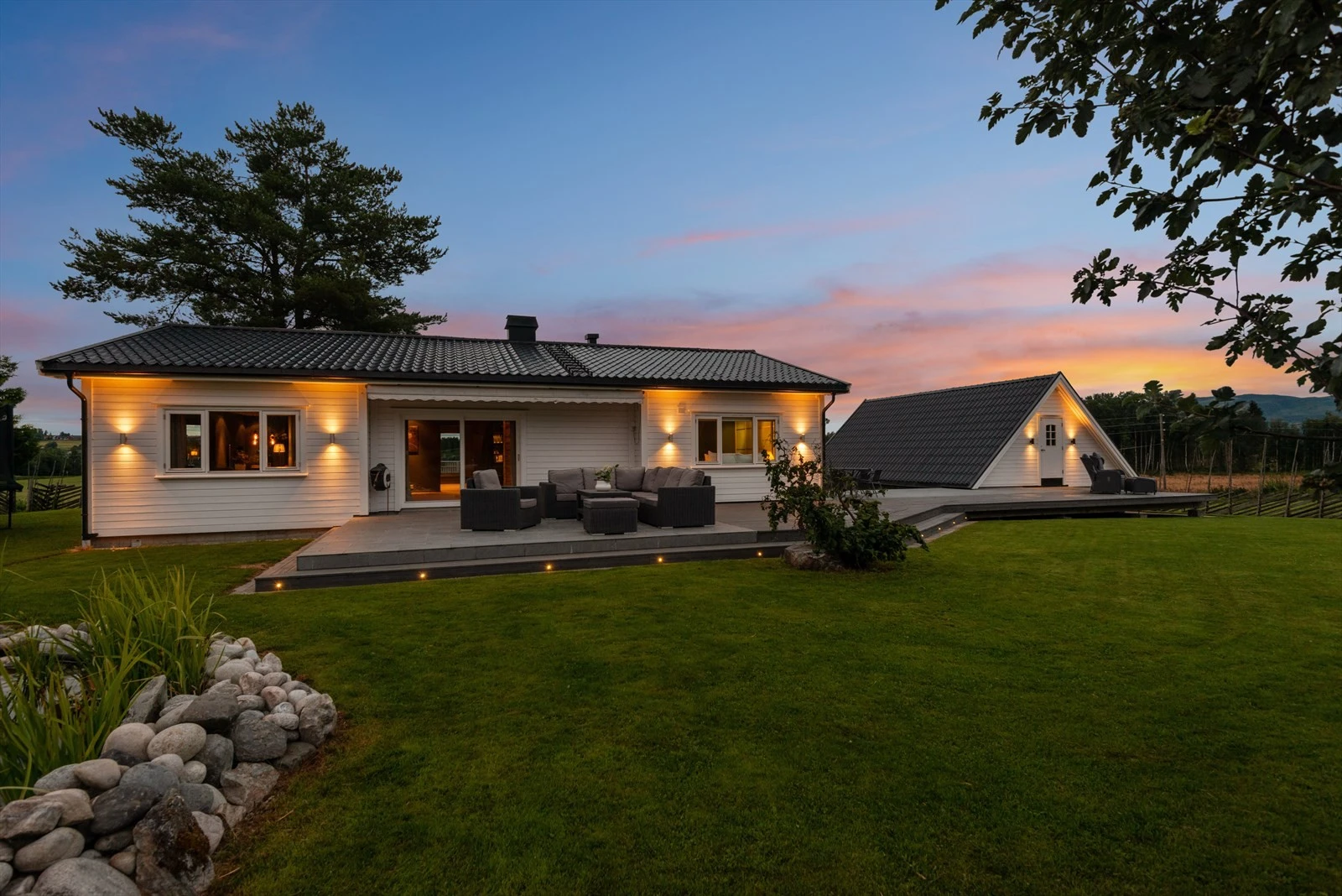 Romslig uteområde med terrasse og flat plen, ideelt for både lek og flere utesoner. Galleribilde