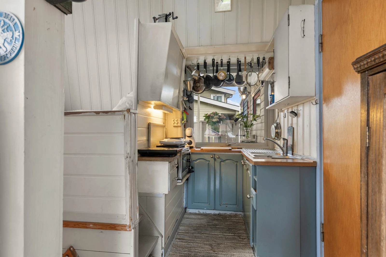 Liten kjøkkenkrok med nyere underskap og benkeplate med vask og innlagt vann. Galleribilde