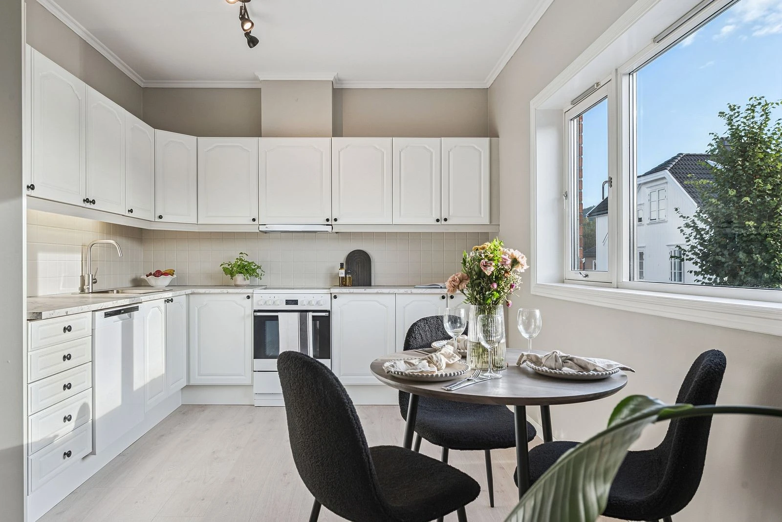 Pent kjøkken med profilerte fronter og laminat benkeplate.