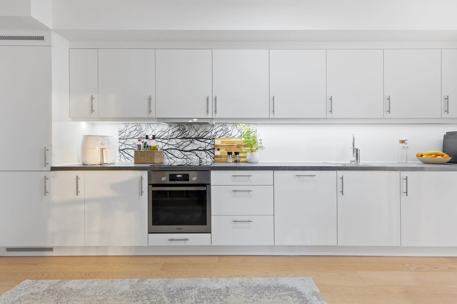 Det er satt inn lyslist mellom over- og underskap. Av utstyr medfølger integrerte hvitevarer som komfyr, induksjonsplatetopp, oppvaskmaskin, samt kombinert kjøle/- og fryseskap. Elektrisk ventilator over kokesonen. Galleribilde