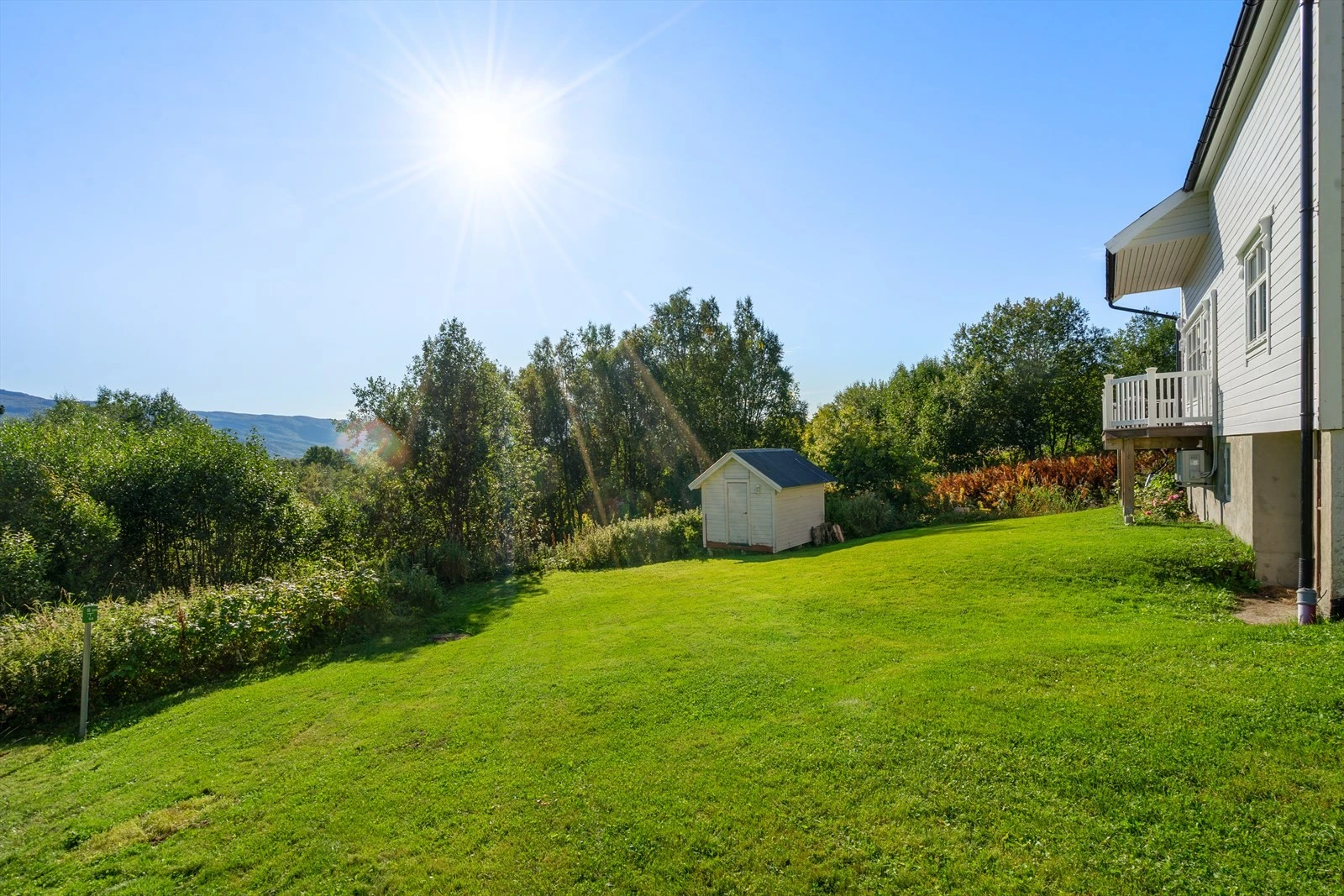 Stor og solrik tomt med god plass til lek, hageprosjekter eller bare å nyte rolige dager i grønne omgivelser Galleribilde