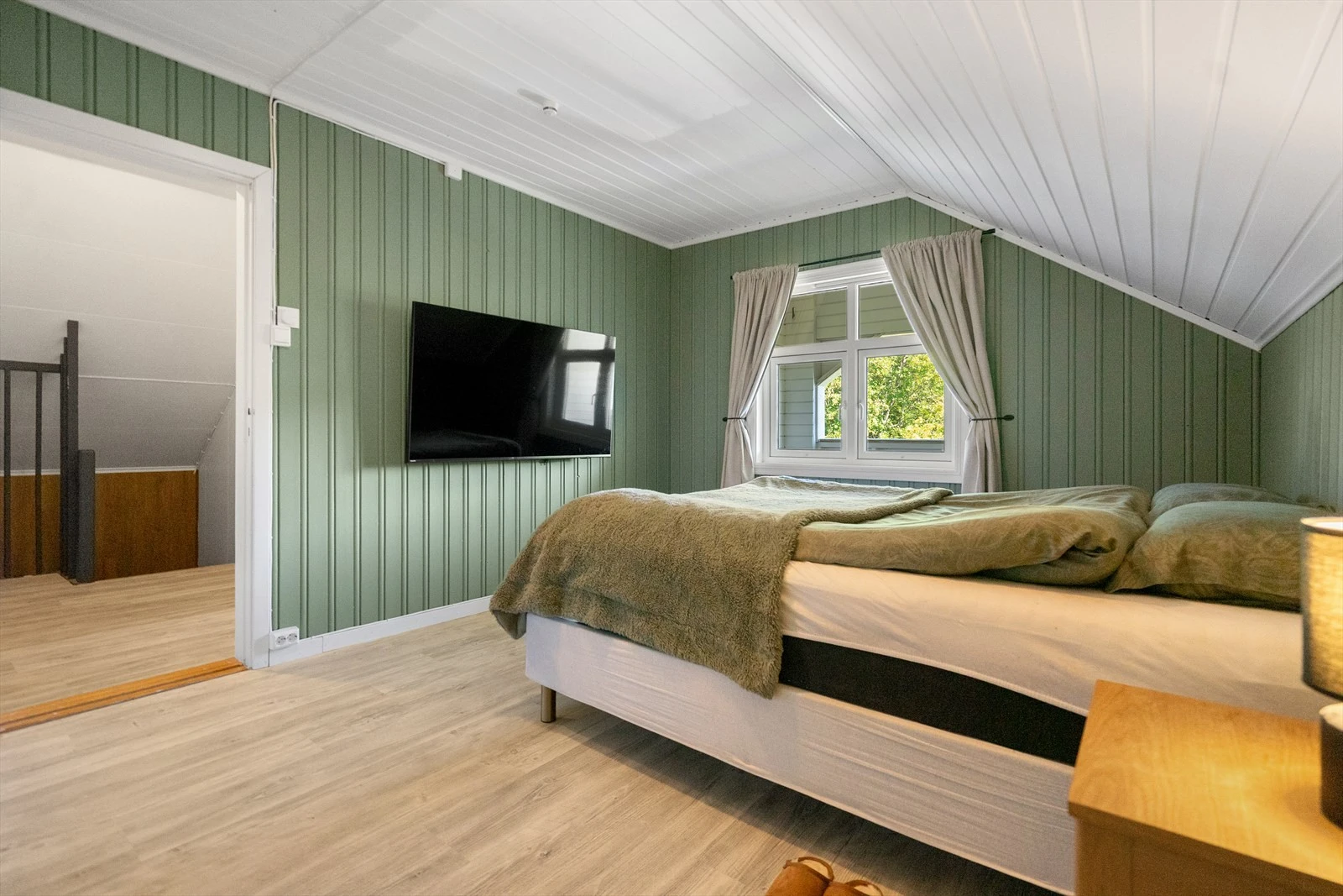 Soverom malt i en flott grønnfarge som slipper naturen inn på soverommet - luftig og god atmosfære hvor du kan slappe av og finne roen Galleribilde