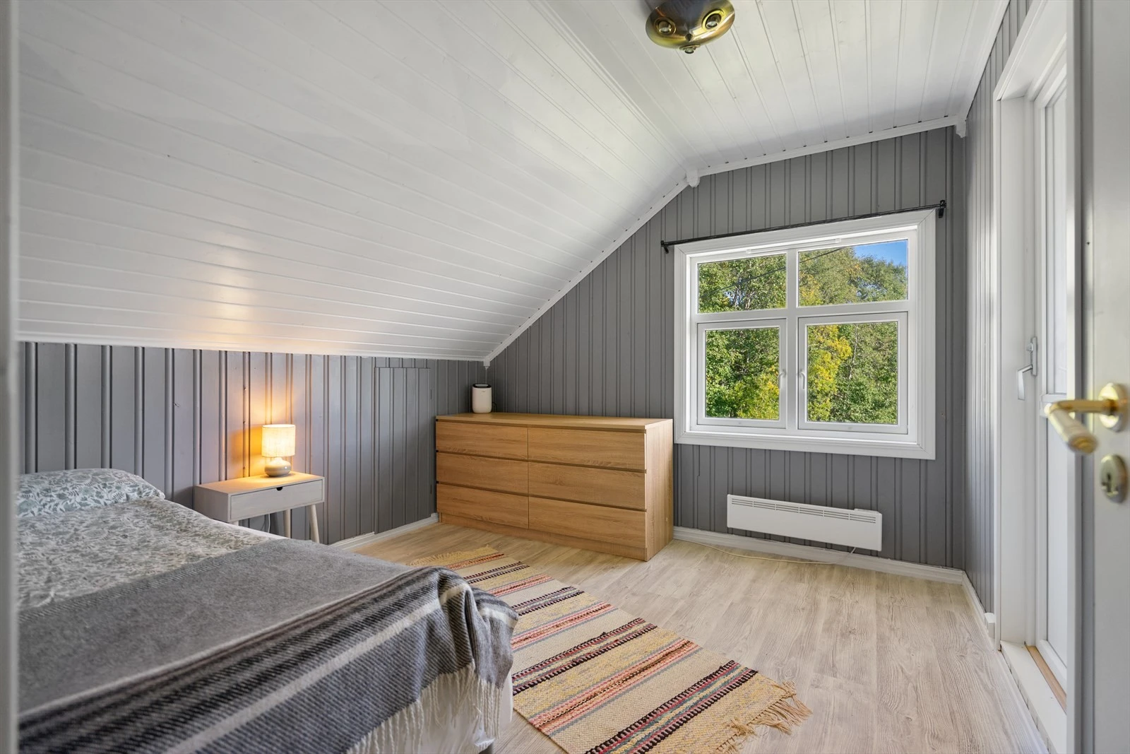 Soverom 2 - romslig soverom med skråtak og lyse overflater, som gir en lun og hyggelig atmosfære Galleribilde