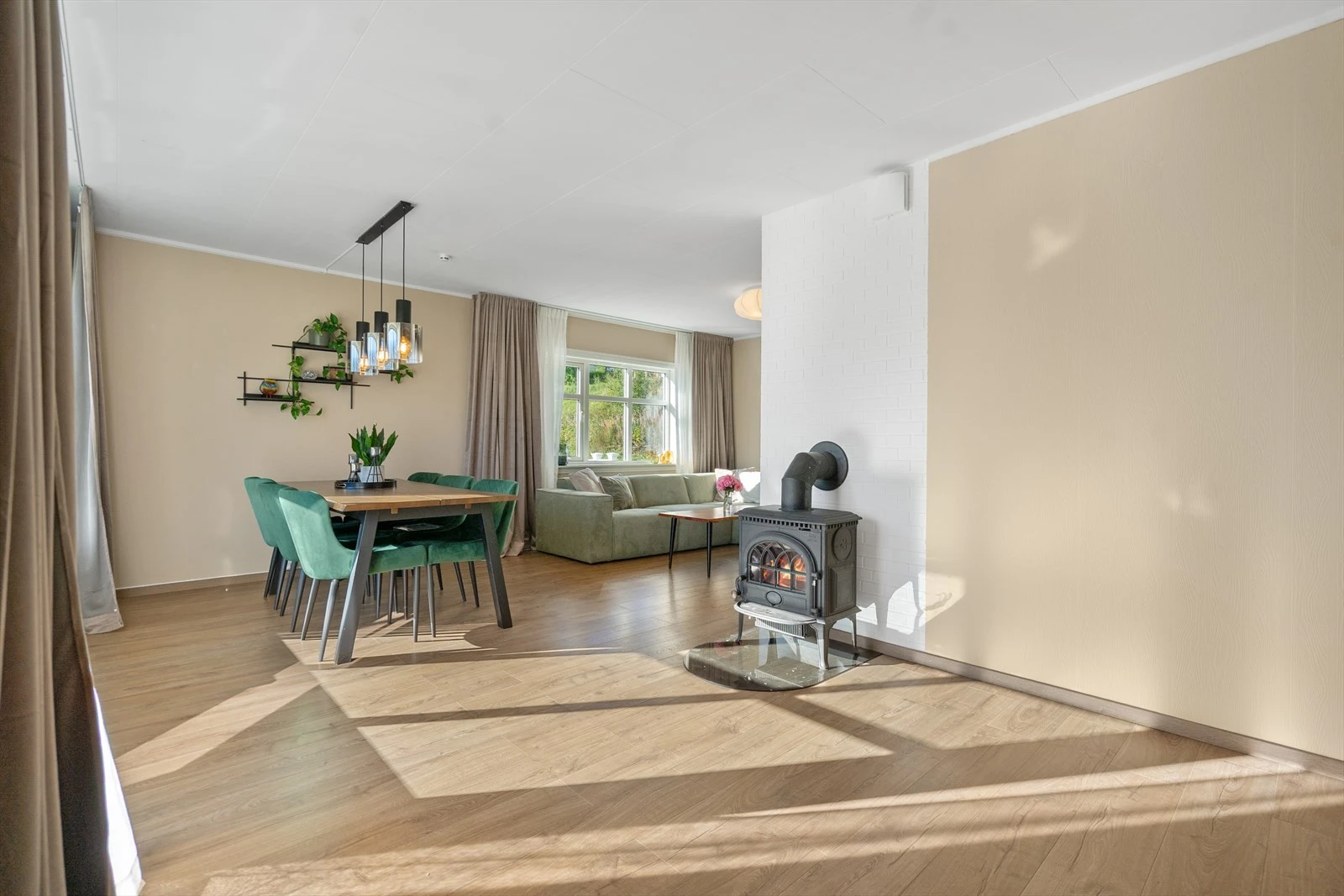 Romslig stue med god plass til både spisebord og sofakrok - perfekt for hyggelige måltider og samvær Galleribilde