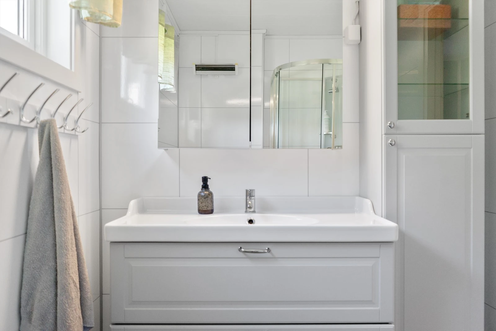 Stilren innredning med servant, speilskap og god oppbevaringsplass Galleribilde