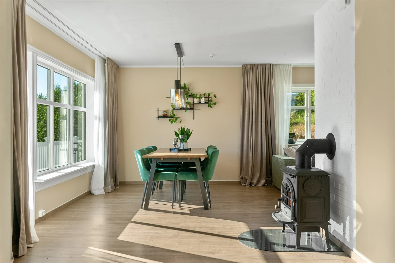 Lys og innbydende spisestue med store vindusflater som slipper inn mye dagslys - og vedovn som gir en lun atmosfære Galleribilde