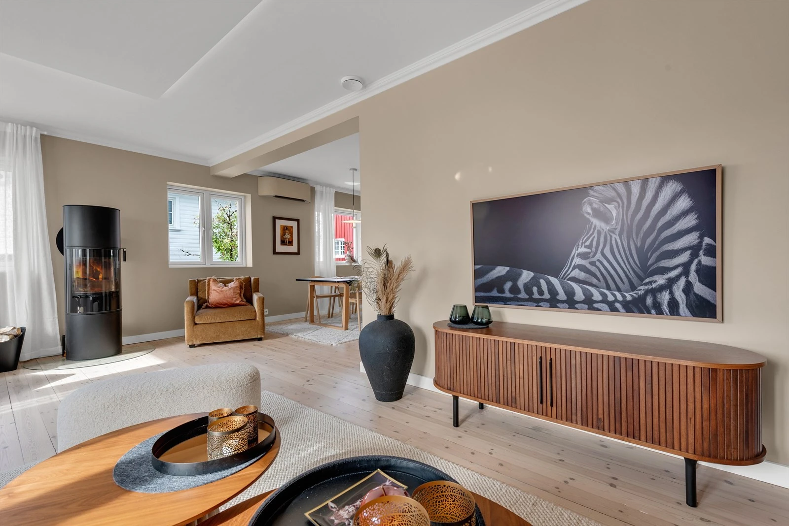 Lys og moderne stue med store vinduer. Åpen planløsning gir romslig atmosfære, ideell for både avslapning og sosiale sammenkomster. Galleribilde