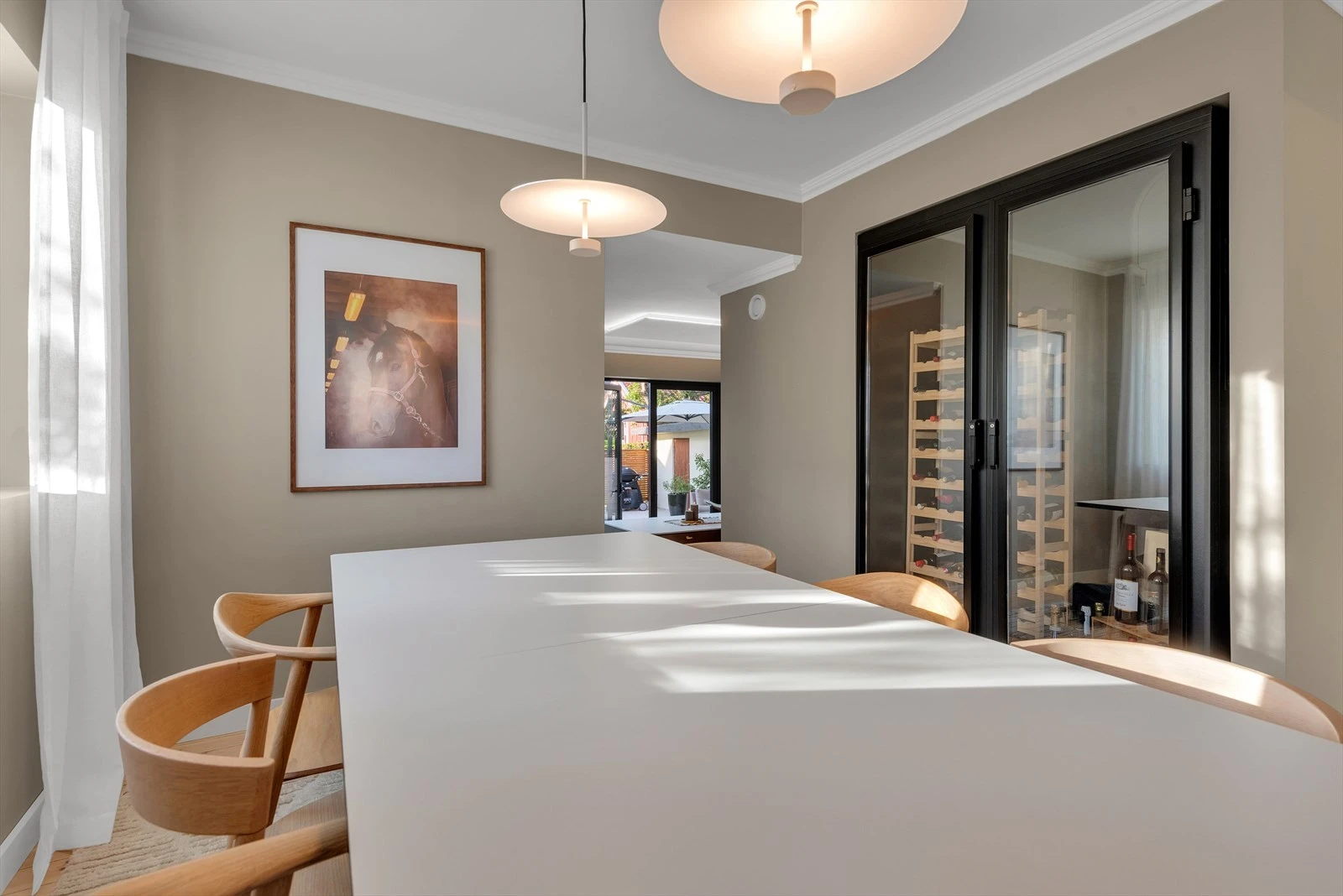 Lys og moderne spisestue med stilfull innredning og elegant belysning, ideell for hyggelige middager og samlinger. Galleribilde