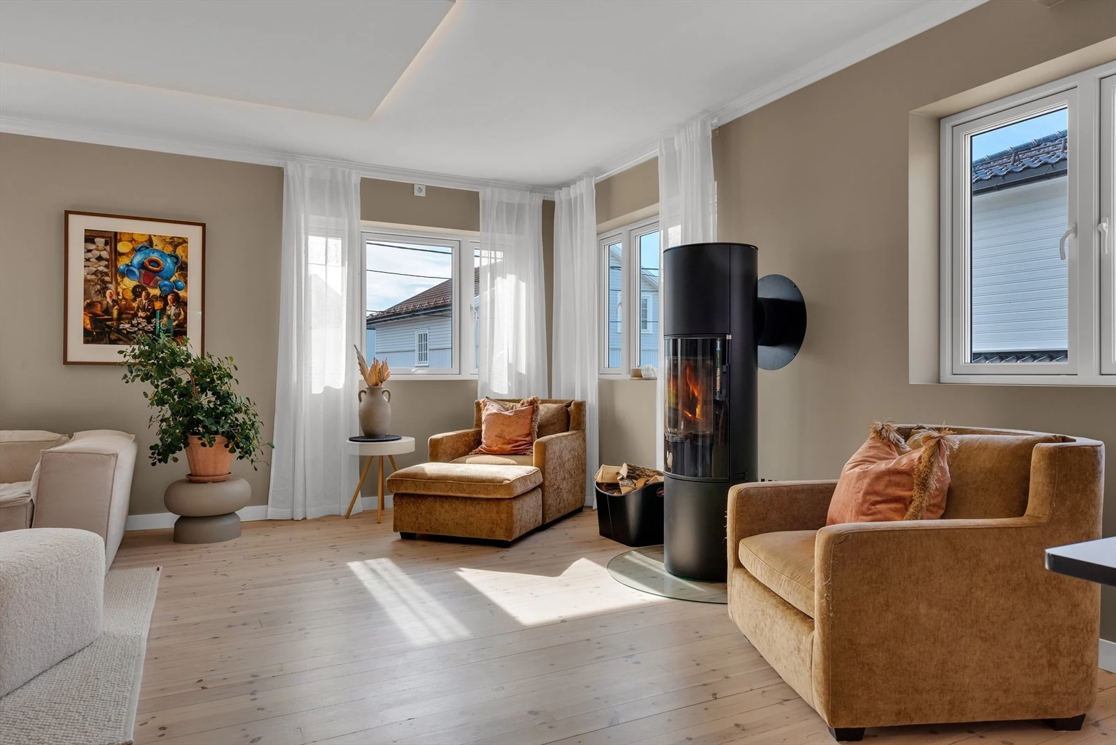 Lys og innbydende stue med store vinduer som slipper inn naturlig lys, perfekt for avslapning og hygge. Galleribilde