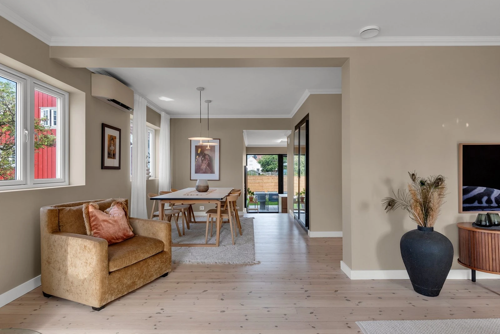 Lys og romslig stue med moderne detaljer og store vinduer som gir rikelig med naturlig lysinnslipp. Galleribilde