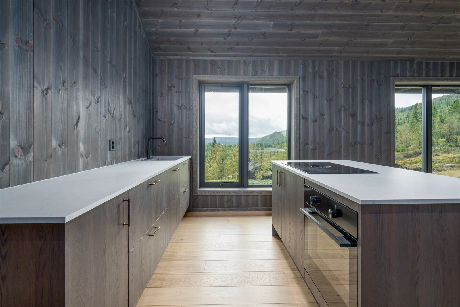 Lekkert kjøkken med integrerte hvitevarer og flott utsikt med store vinduer Galleribilde