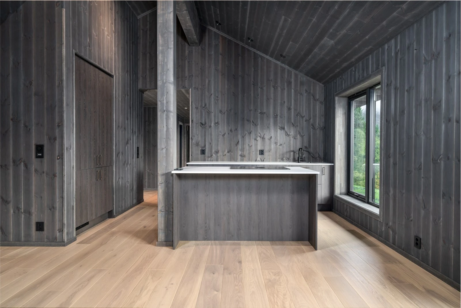 Kjøkken med nisje der høyskap og kjøl og frye er integrert i veggen Galleribilde