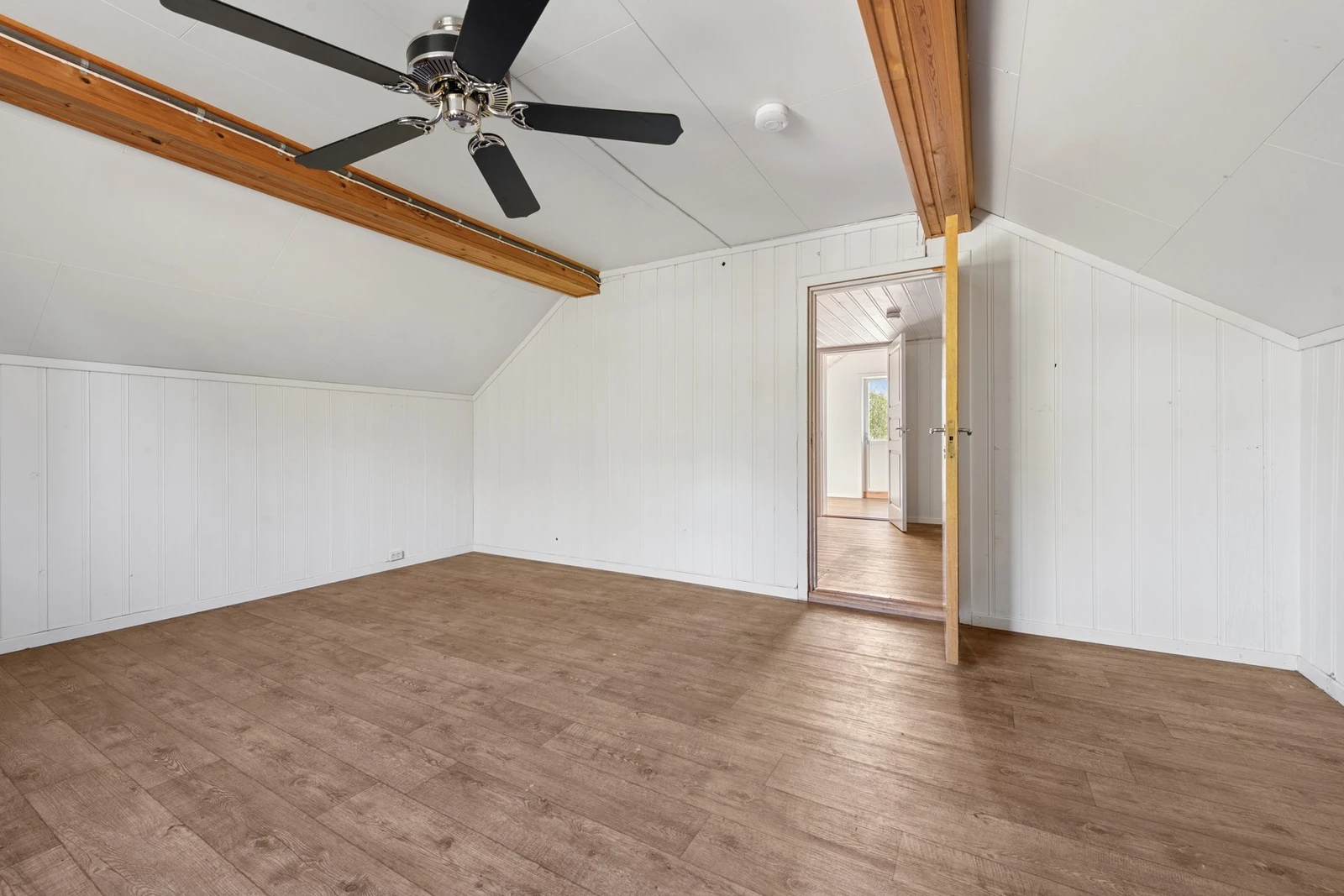 Et av soverommene i andre etasje byr på god gulvflate og takhøyde med synlige dragere som gir rommet særpreg. Galleribilde