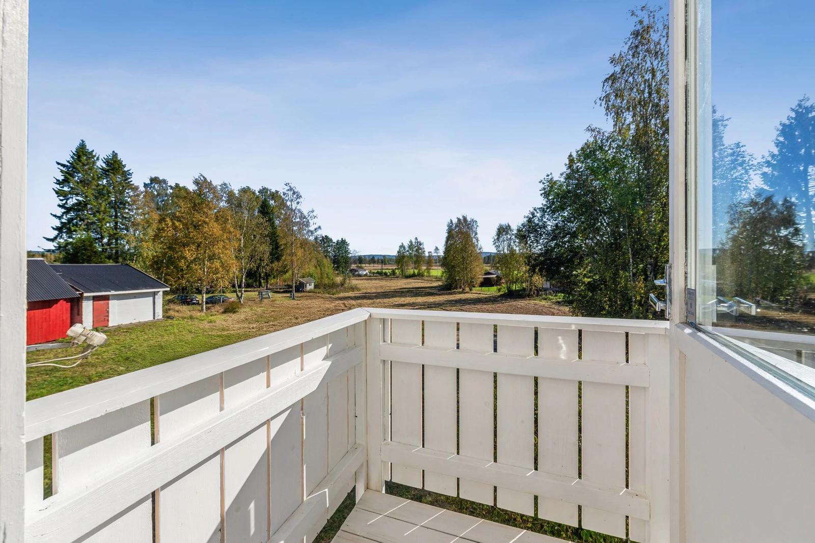 Fra den lille balkongen i andre etasje har du utsyn over tomten og landlige omgivelser. Galleribilde