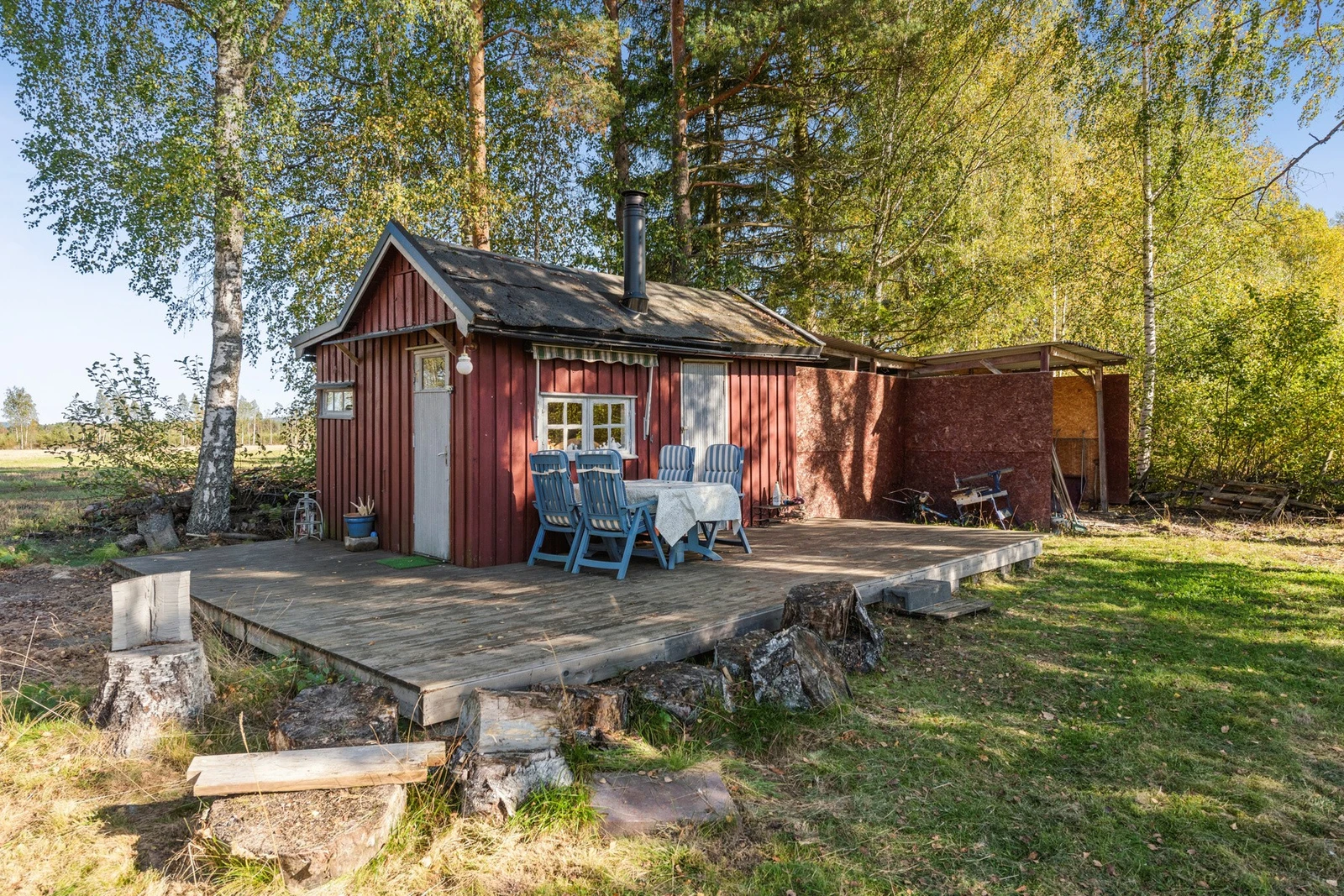 På tomten finnes det også en liten hytte med vedovn og tilhørende terrasse. Dette gir en ekstra mulighet for fritidsbruk, gjester eller som et hyggelig sted å trekke seg tilbake. Galleribilde