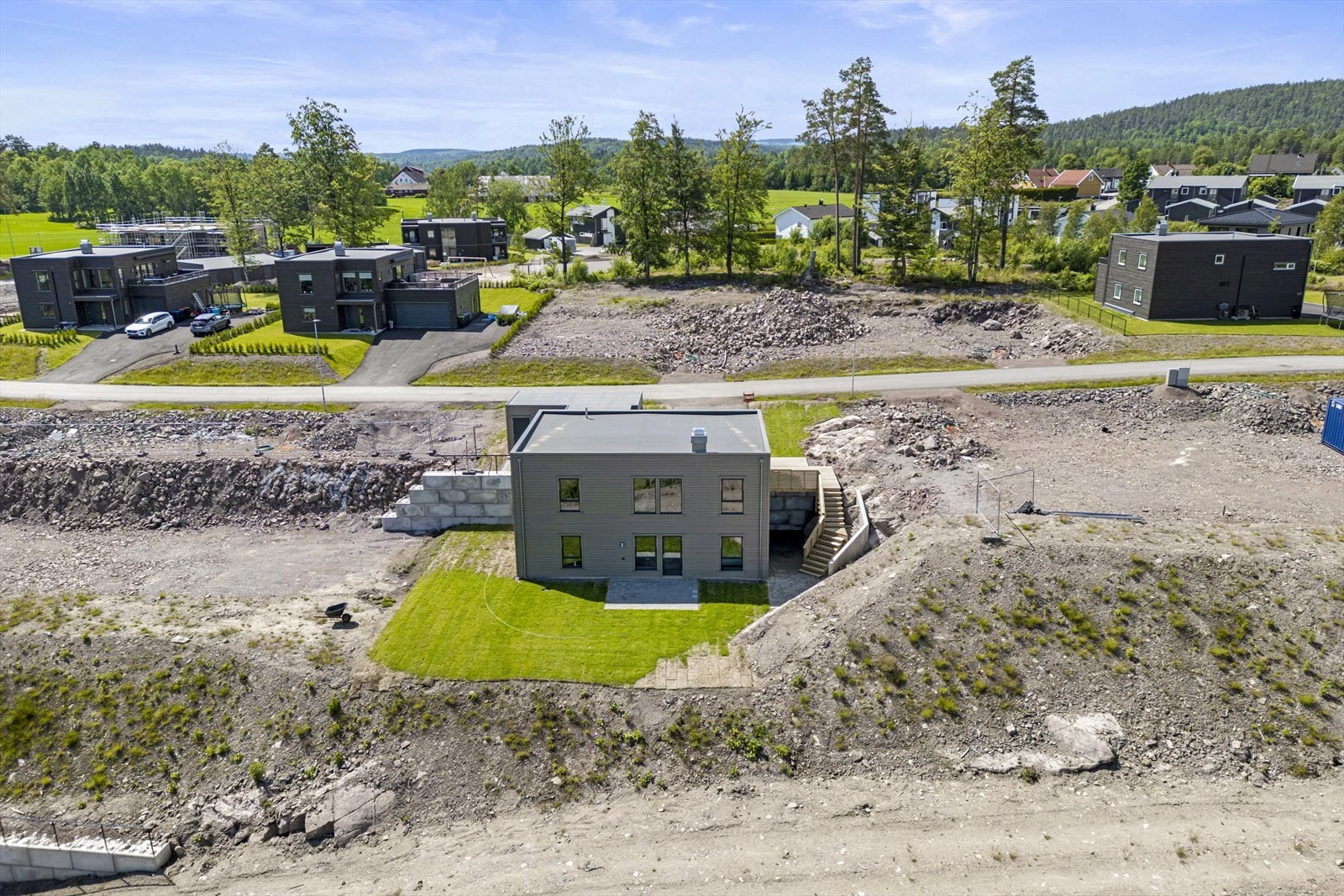 Her er en bolig ferdig og klar for ny eier. På hver sin side og over veien er det ledige tomter som kan kjøpes. Galleribilde