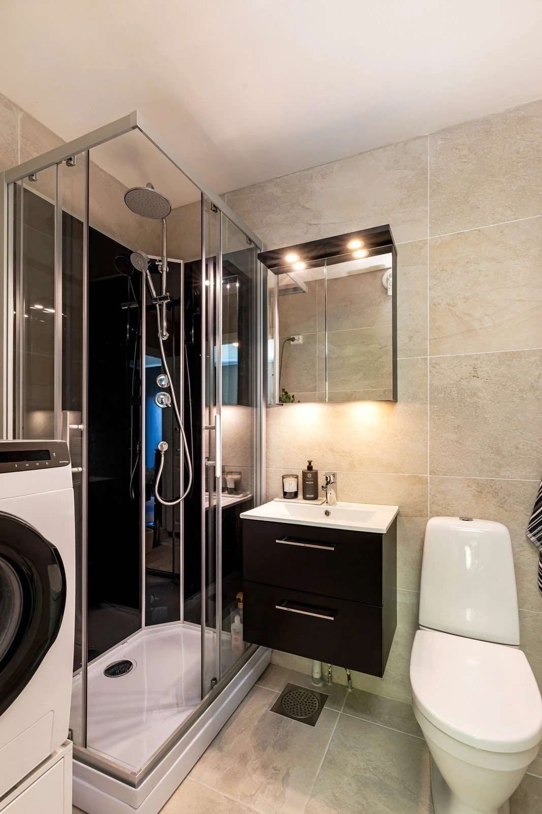 Badet er bl.a. innredet med dusjkabinett, vegghengt servantmøbel og vegghengt overskap med lys og speil. Galleribilde