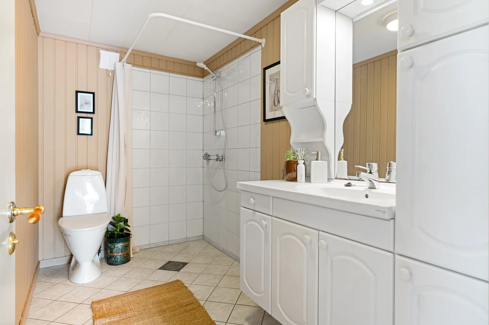 Badet i 1. etg er på ca. 4,4 m² og består av dusjhjørne, gulvmontert toalett og innredning med servant. Galleribilde