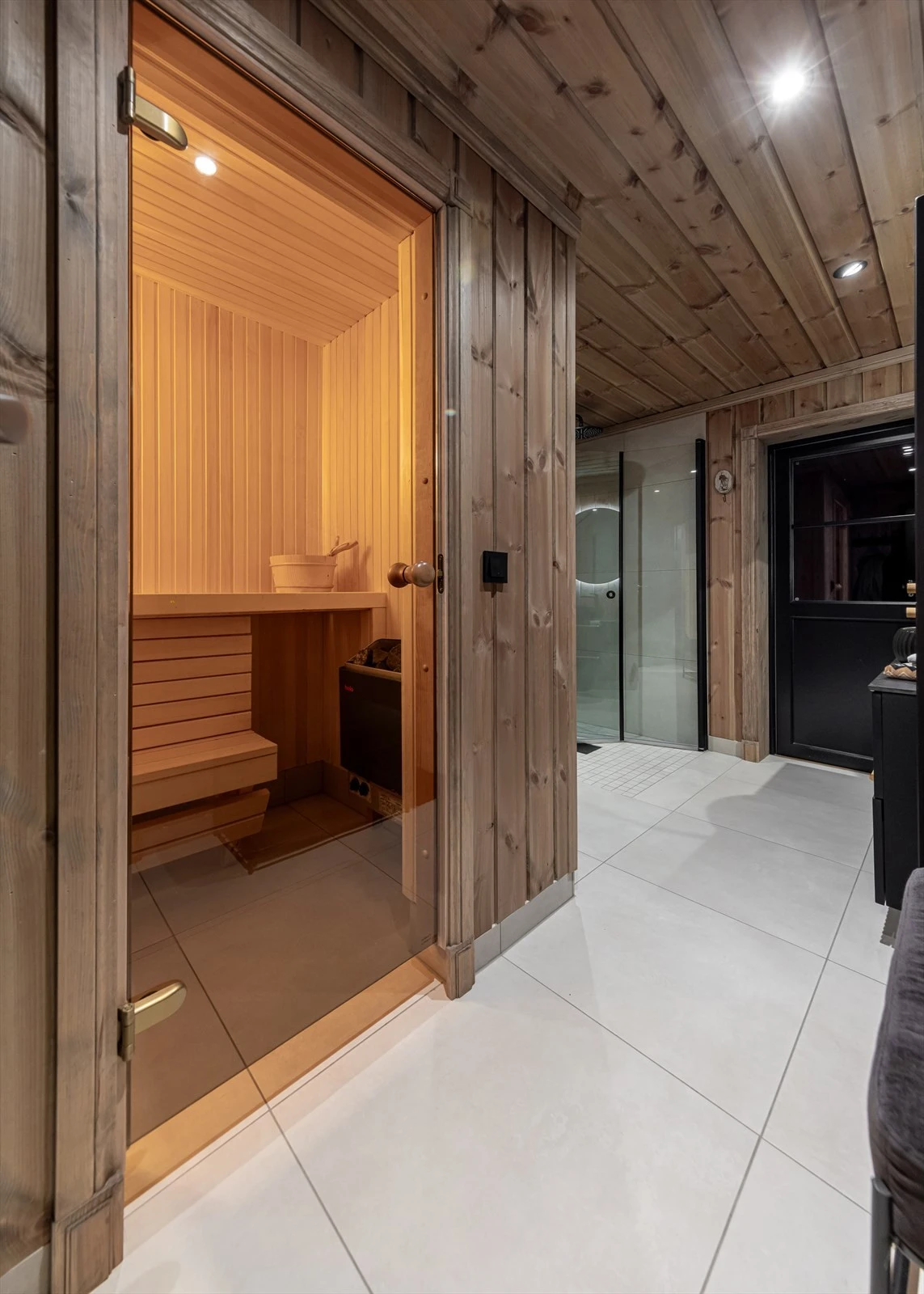 Baderommet er utstyrt med dusjhjørne, innfellbare dusjdører, veggmontert wc, servant, servantskap og mekanisk avtrekk, samt badstue Galleribilde