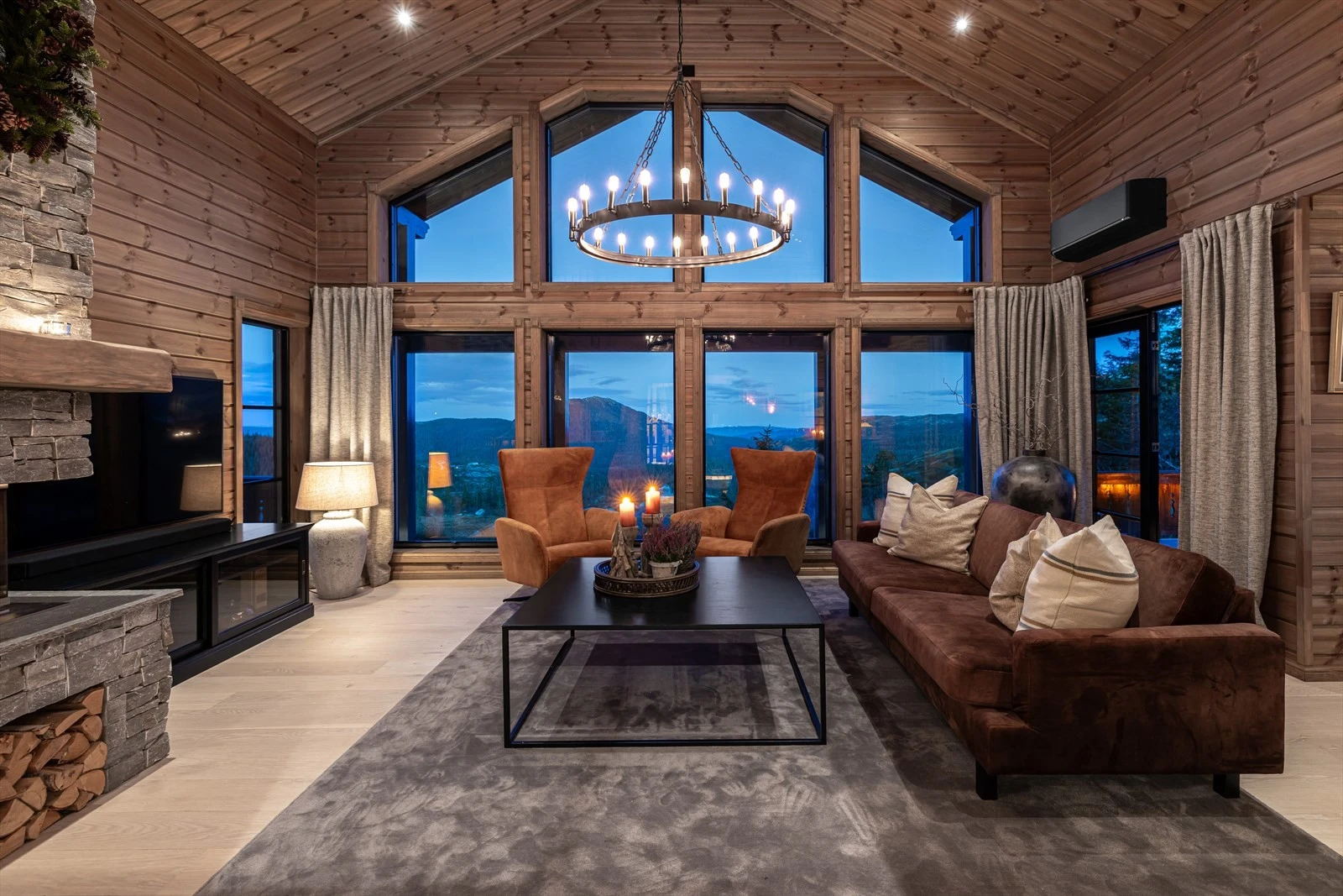 Lys og luftig stue med store vinduer og åpen takhøyde som gir en romslig atmosfære Galleribilde