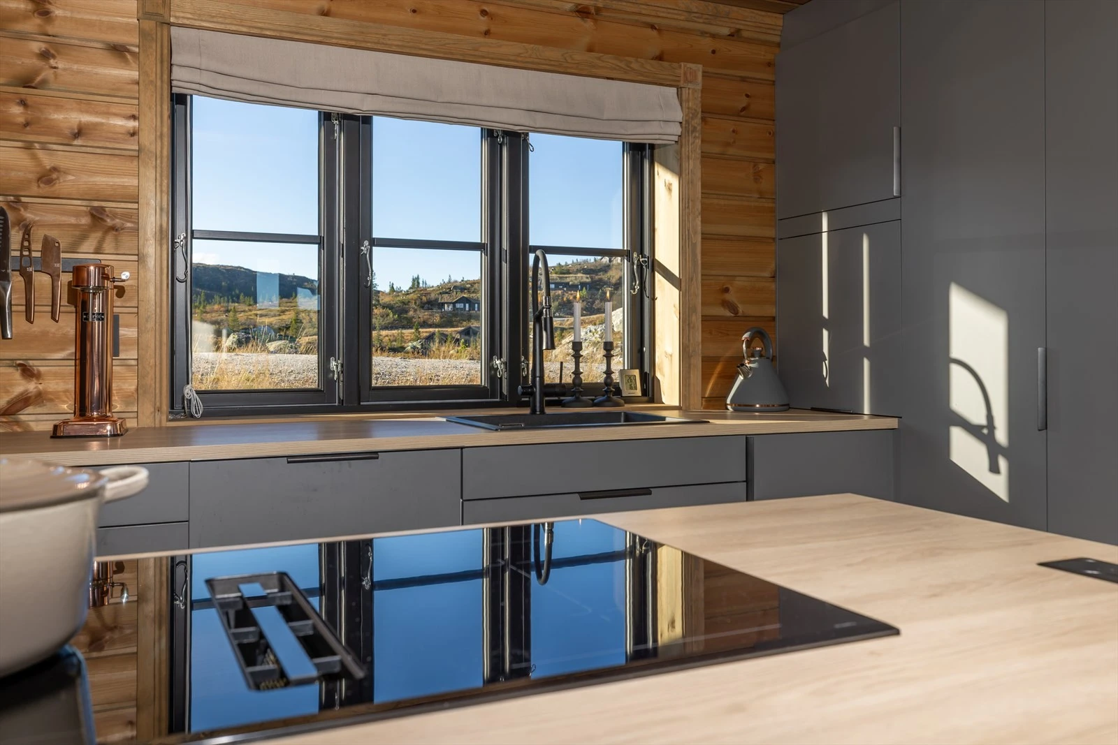 Kjøkkenet er innredet med induskjonstopp med integrert kullfiltervifte. Galleribilde