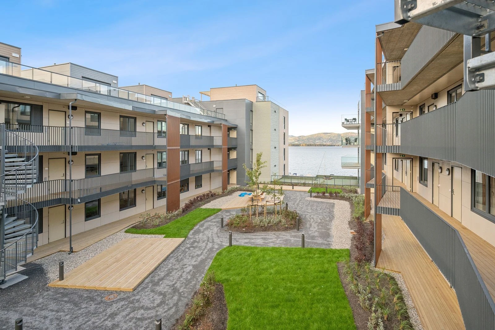 Godt vedlikeholdte fellesarealer med benker, grønt og beplantning.