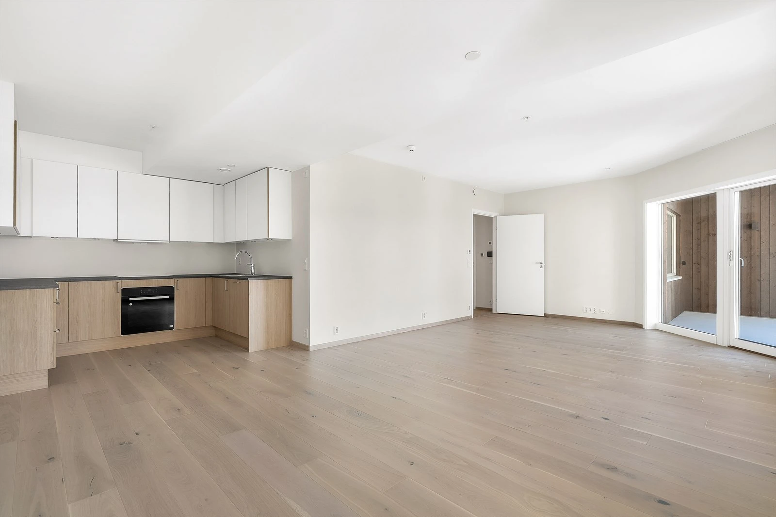 Moderne åpen løsning med spisestue, kjøkken og stue.